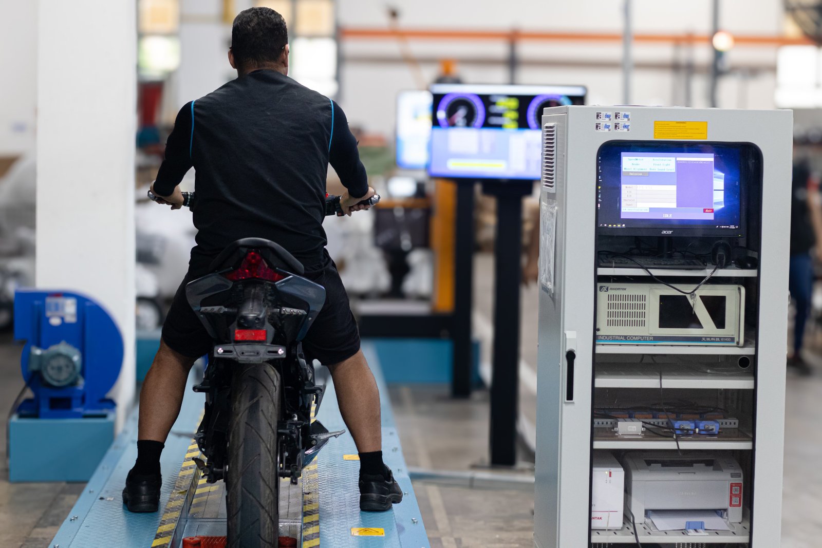 a man riding a motorcycle in a factory
