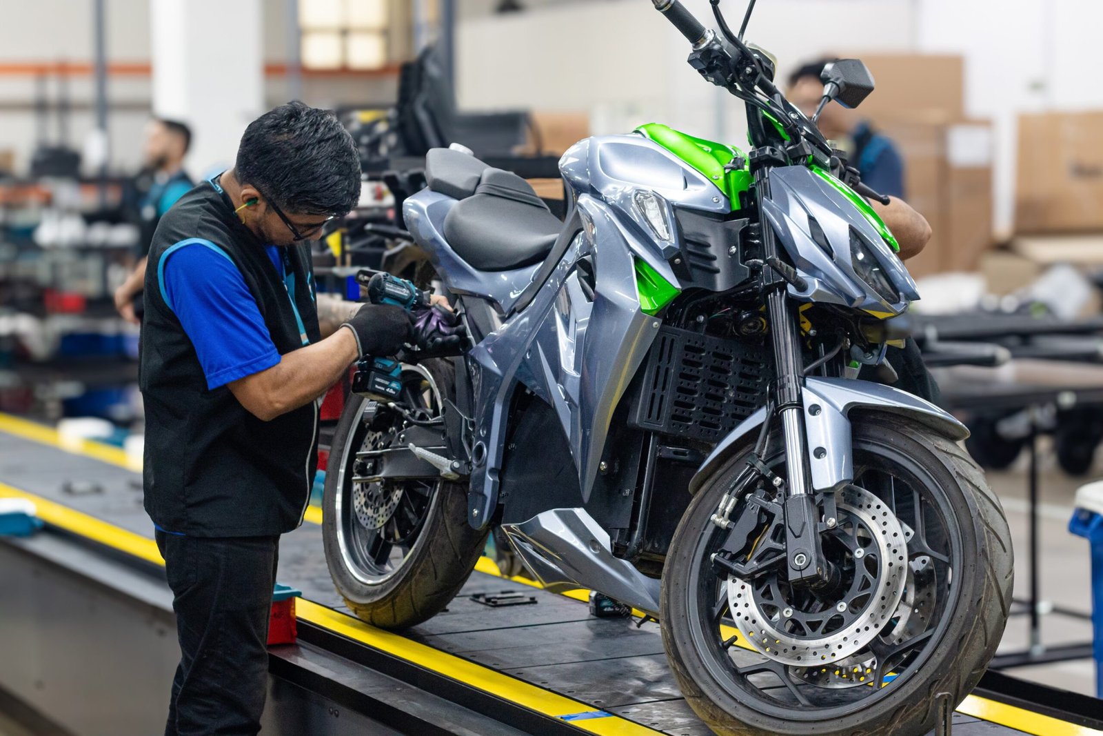 a man working on a motorcycle in a factory